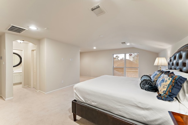 bedroom with arched walkways, visible vents, light carpet, and baseboards