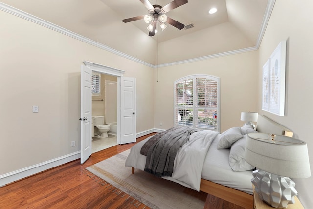 bedroom featuring visible vents, ornamental molding, connected bathroom, wood finished floors, and baseboards