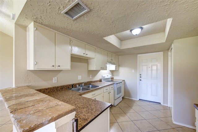 kitchen featuring a tray ceiling, white range with electric cooktop, visible vents, a sink, and a textured ceiling