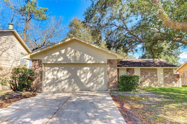 single story home with concrete driveway, brick siding, and an attached garage