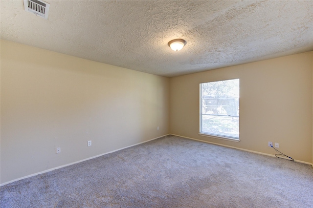 carpeted spare room with visible vents, a textured ceiling, and baseboards