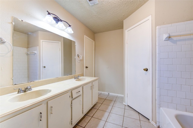 full bath featuring a textured ceiling, a sink, visible vents, and tile patterned floors