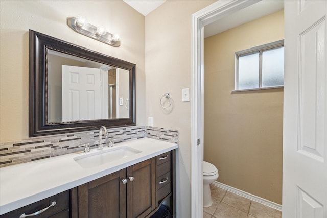 bathroom with toilet, tile patterned flooring, decorative backsplash, baseboards, and vanity