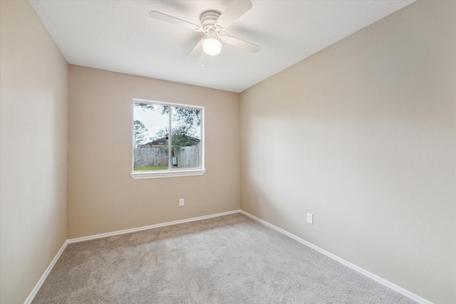 unfurnished room with baseboards, carpet floors, and a ceiling fan