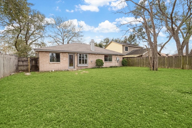 back of house with roof with shingles, a yard, a fenced backyard, a chimney, and brick siding