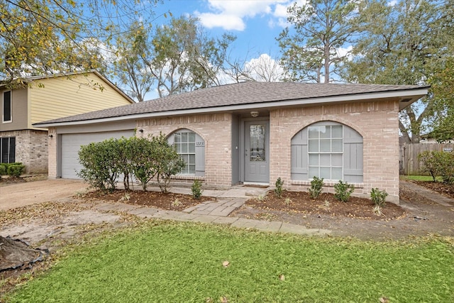 view of front facade featuring fence, an attached garage, a shingled roof, concrete driveway, and brick siding