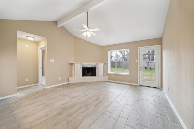 unfurnished living room featuring baseboards, lofted ceiling with beams, light wood-style flooring, a fireplace, and a ceiling fan