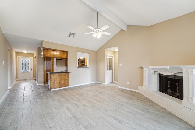 unfurnished living room featuring visible vents, a fireplace, lofted ceiling with beams, and light wood-style floors