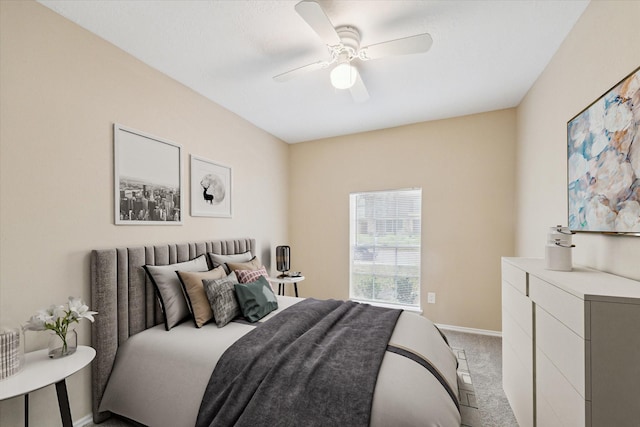 bedroom with a ceiling fan, light colored carpet, and baseboards