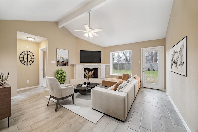 living area with lofted ceiling with beams, baseboards, a fireplace with raised hearth, and wood tiled floor