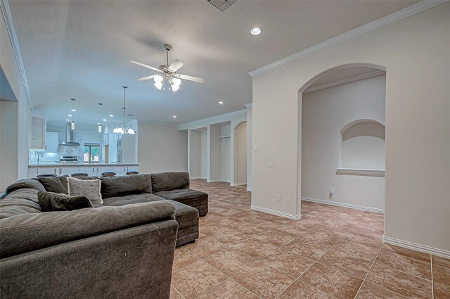 living room featuring arched walkways, crown molding, recessed lighting, baseboards, and ceiling fan with notable chandelier