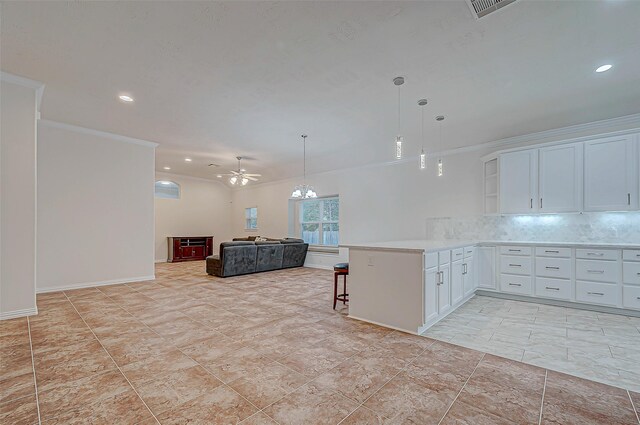 kitchen with backsplash, ornamental molding, open floor plan, white cabinetry, and a peninsula