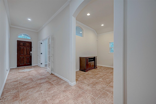 foyer entrance featuring recessed lighting, baseboards, arched walkways, and ornamental molding