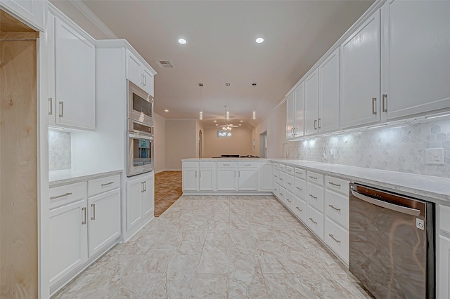 kitchen with stainless steel appliances, a peninsula, white cabinets, light countertops, and decorative backsplash