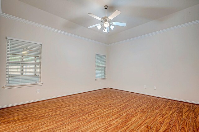 empty room featuring baseboards, ceiling fan, ornamental molding, and wood finished floors