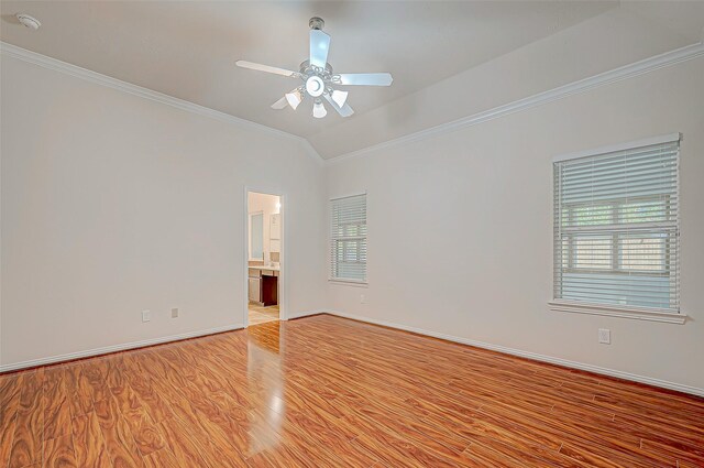 empty room with lofted ceiling, ornamental molding, light wood-style flooring, and a healthy amount of sunlight