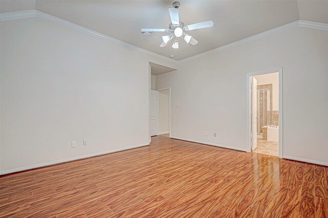 unfurnished bedroom featuring light wood-style floors, baseboards, ornamental molding, and vaulted ceiling