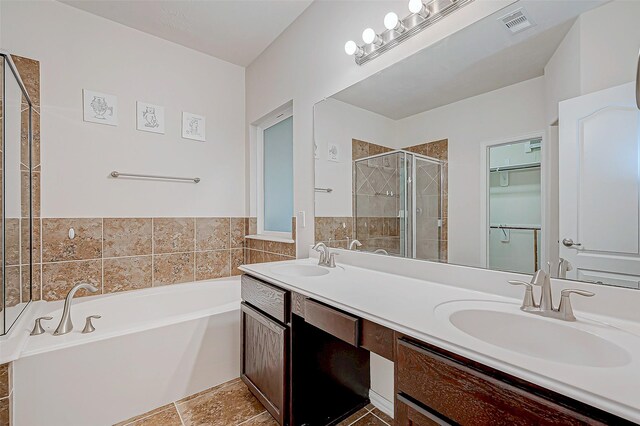 bathroom with double vanity, a sink, a shower stall, and a bath