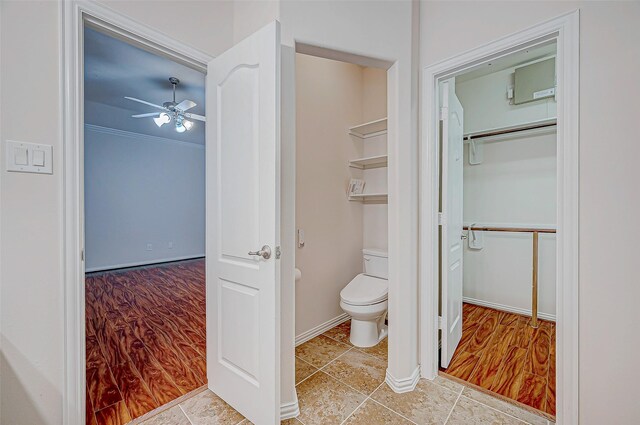 bathroom with toilet, tile patterned flooring, baseboards, and a ceiling fan