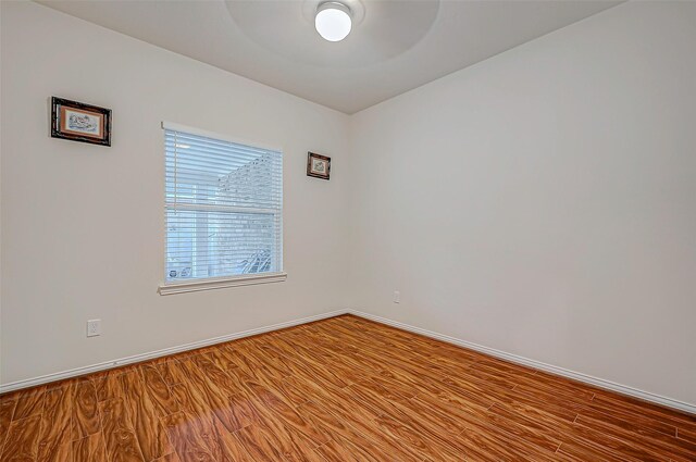 spare room featuring wood finished floors and baseboards