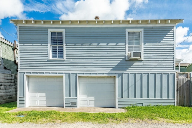 back of property with an attached garage, fence, and cooling unit