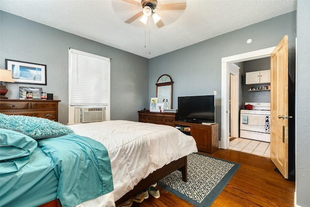 bedroom featuring cooling unit, ceiling fan, a textured ceiling, and wood finished floors