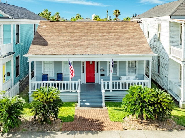 bungalow-style house with a tile roof, a porch, and roof with shingles