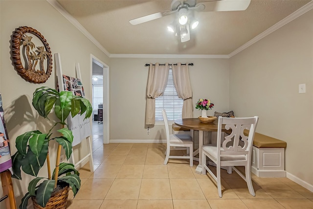 dining space featuring a ceiling fan, baseboards, crown molding, and light tile patterned flooring