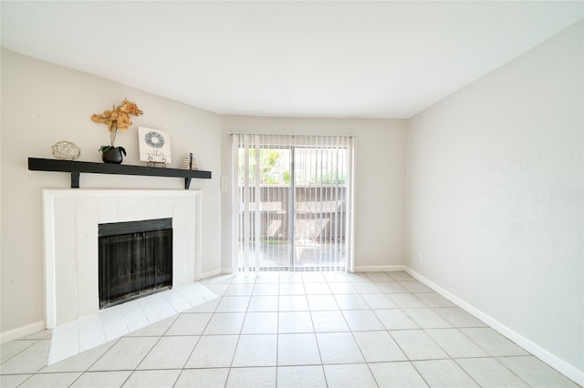 unfurnished living room with tile patterned flooring, a tiled fireplace, and baseboards