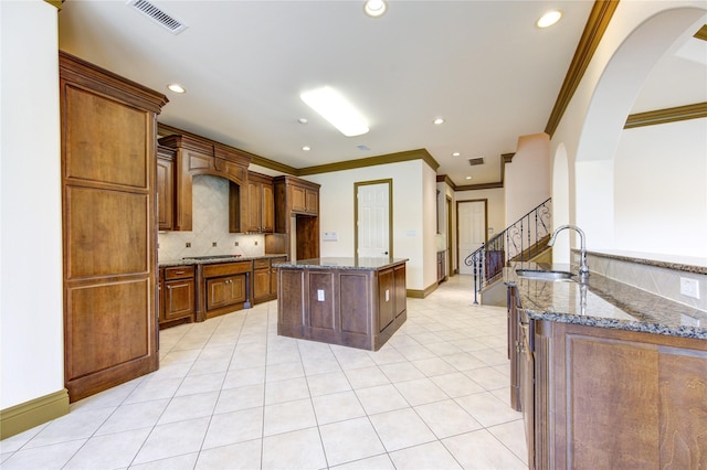 kitchen featuring tasteful backsplash, visible vents, a sink, and dark stone countertops