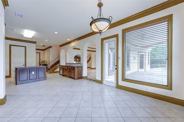 interior space featuring light tile patterned floors, stairway, a sink, and baseboards