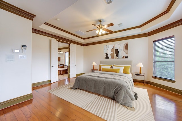 bedroom featuring hardwood / wood-style floors, a raised ceiling, and visible vents