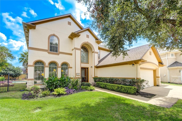 mediterranean / spanish-style house with driveway, a front yard, fence, and stucco siding