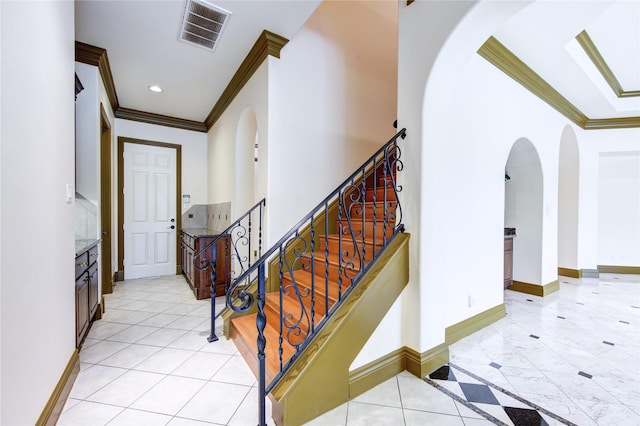 foyer entrance featuring ornamental molding, visible vents, baseboards, and light tile patterned floors