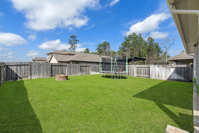 view of yard with a trampoline and a fenced backyard