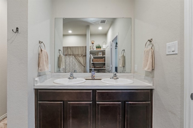 full bath with double vanity, visible vents, and a sink