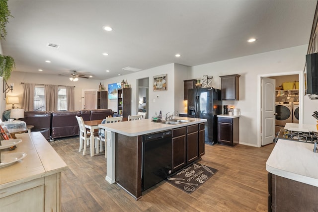 kitchen with light countertops, visible vents, washing machine and dryer, dark brown cabinets, and black appliances