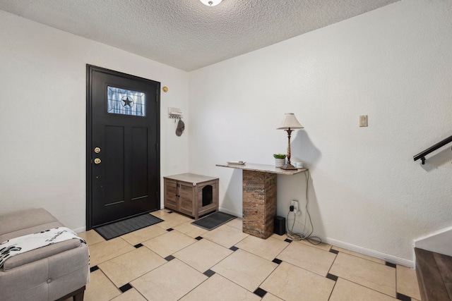 entryway with a textured ceiling, light tile patterned flooring, and baseboards