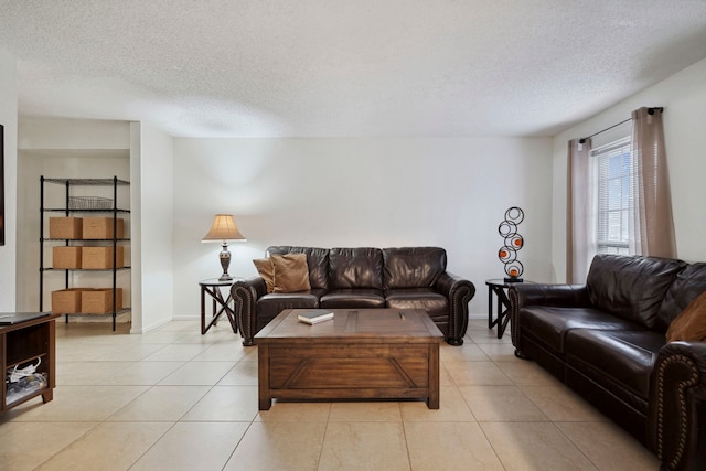 living area with a textured ceiling, baseboards, and light tile patterned floors