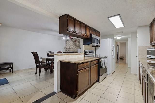 kitchen featuring light tile patterned floors, light stone counters, stainless steel appliances, and backsplash