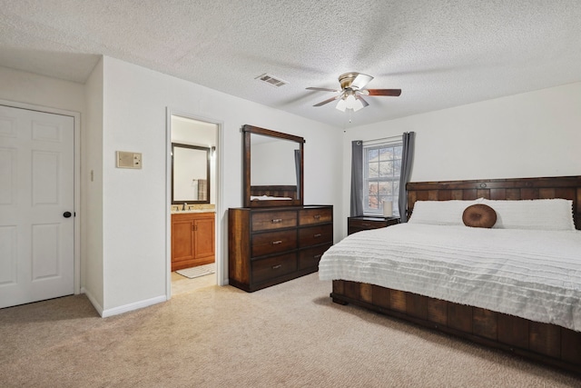 bedroom featuring visible vents, connected bathroom, light colored carpet, a textured ceiling, and a sink