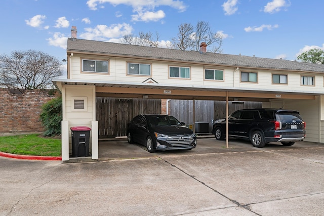 covered parking lot featuring fence