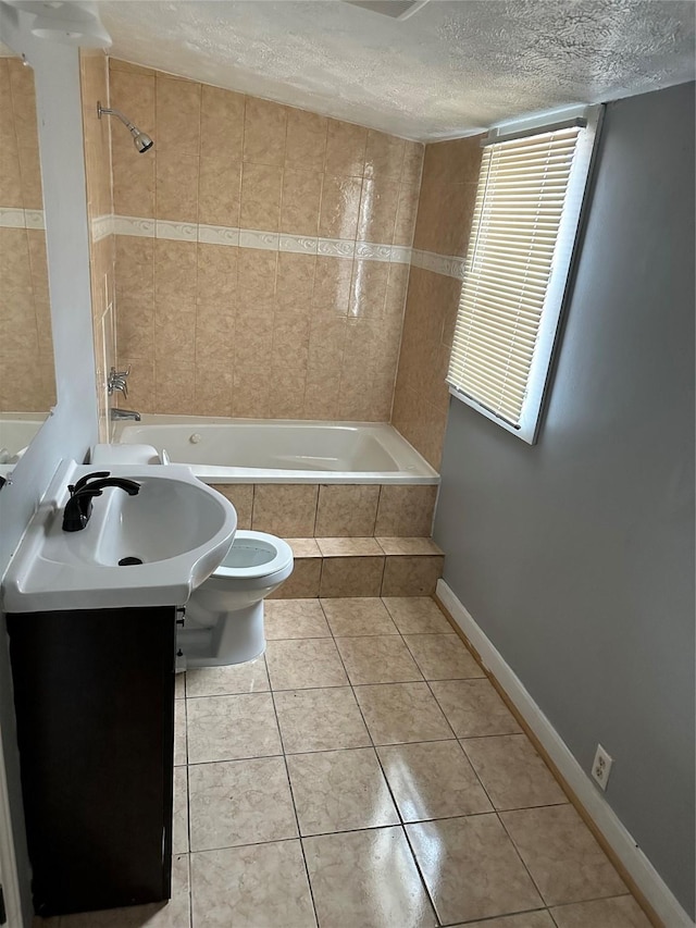 full bath featuring a textured ceiling, tile patterned flooring, toilet, baseboards, and tiled shower / bath