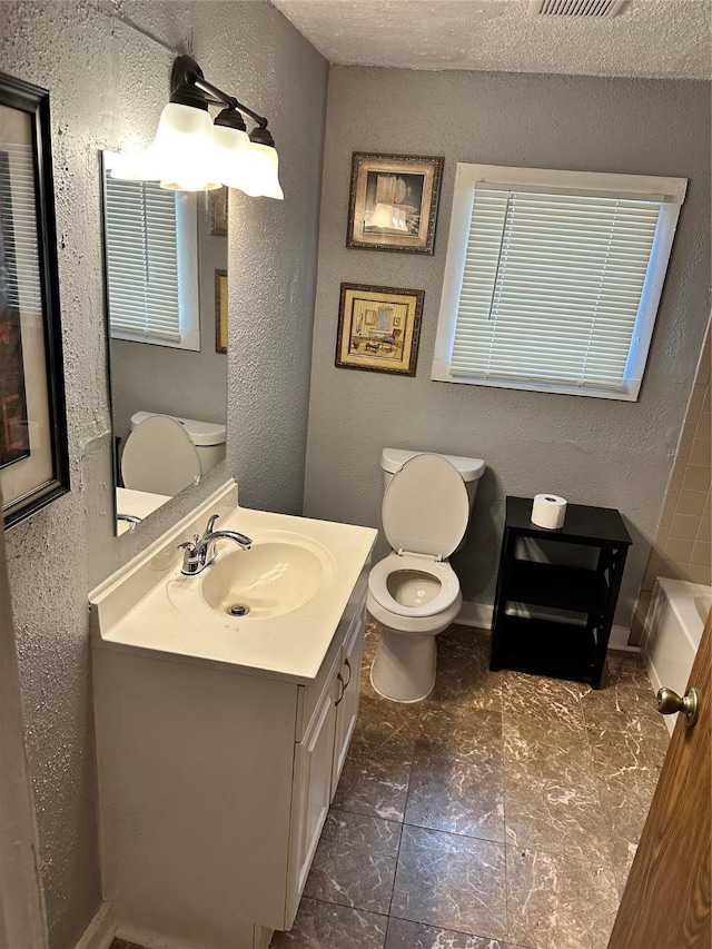 full bathroom with visible vents, a textured wall, toilet, a textured ceiling, and vanity