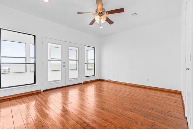 spare room featuring baseboards, ceiling fan, and light wood-style floors