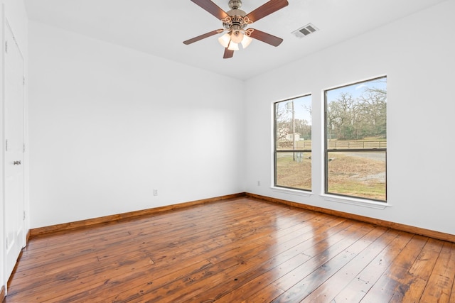 unfurnished room featuring a ceiling fan, baseboards, visible vents, and hardwood / wood-style floors