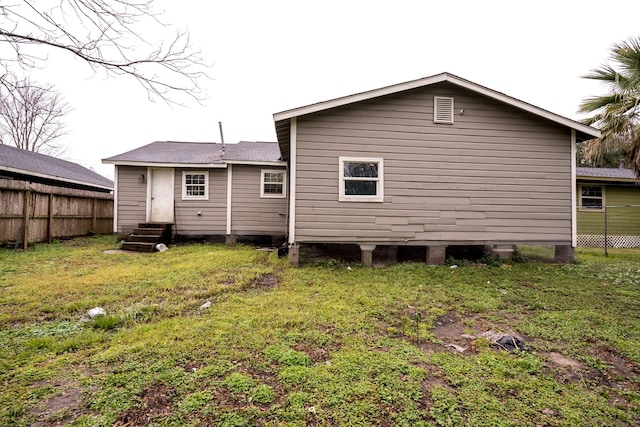 9422 Crestview Dr, Houston, TX 77078 - back of property with entry steps, a shingled roof, fence, and a lawn