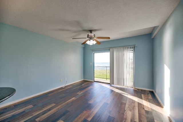 spare room with a textured ceiling, wood finished floors, a ceiling fan, and baseboards