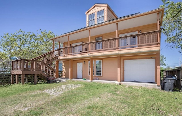 back of house featuring a garage, driveway, stairs, and a yard