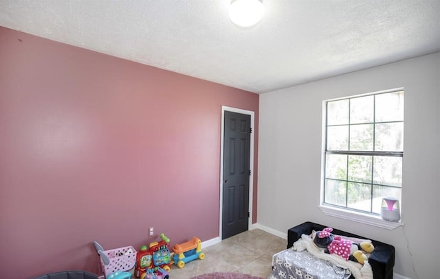 bedroom with a textured ceiling, baseboards, and light tile patterned floors